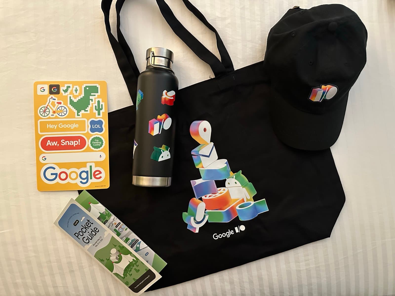 Google I/O tote bag, water bottle, cap, stickers and pocket guide laid out